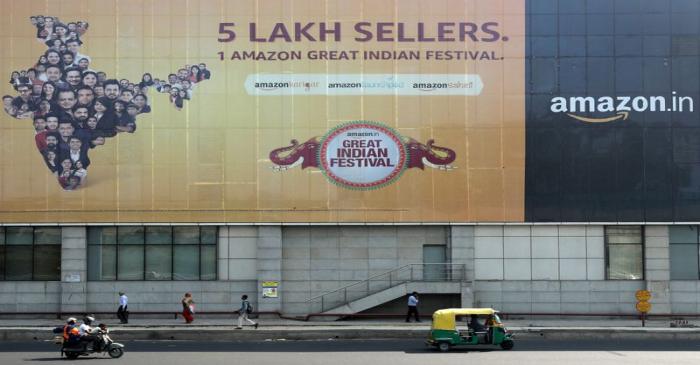 FILE PHOTO: People move past a hoarding of Amazon India outside a metro rail station in New
