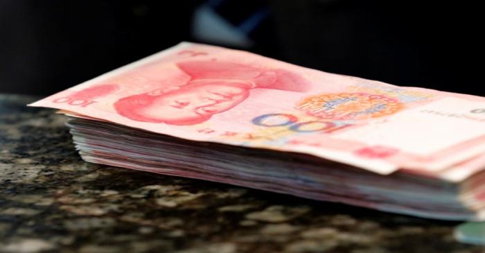 Chinese 100 yuan banknotes are seen on a counter of a branch of a commercial bank in Beijing