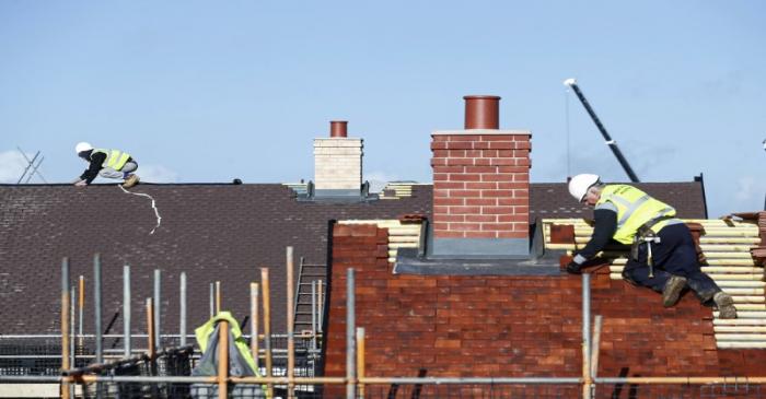 Construction workers work on a Taylor Wimpey housing estate in Aylesbury