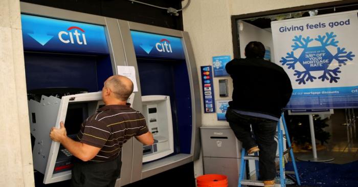 FILE PHOTO: A worker replaces an ATM machine at a bank building on  Shattuck Avenue, in