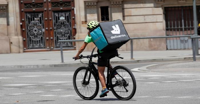 FILE PHOTO: A biker wearing a Deliveroo backpack drives in the central Barcelona