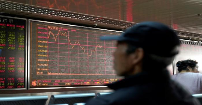 An investor looks at a stock quotation board at a brokerage office in Beijing