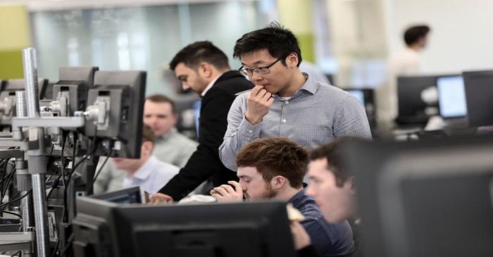 Traders looks at financial information on computer screens on the IG Index trading floor