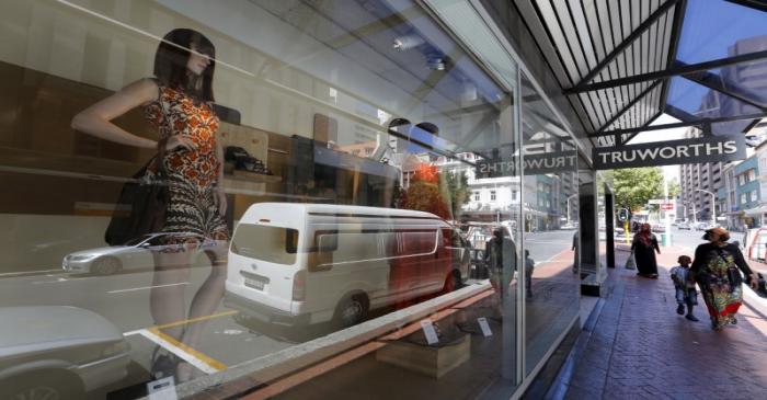 Pedestrians walk past a branch of South African clothing retailer Truworths in Cape Town