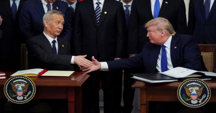 Chinese Vice Premier Liu He and U.S. President Donald Trump shake hands after signing 