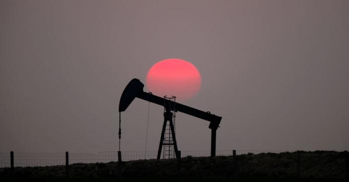 FILE PHOTO: The sun sets behind a pump-jack outside Saint-Fiacre