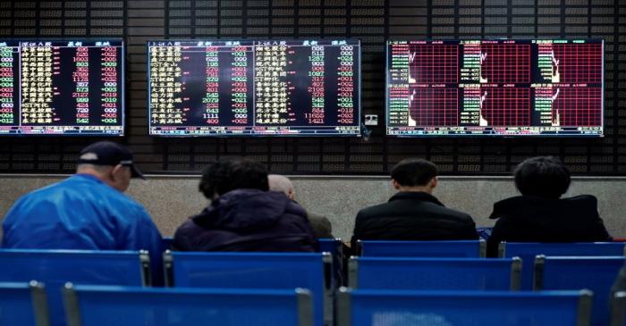 Investors look at screens showing stock information at a brokerage house in Shanghai