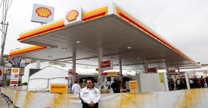 FILE PHOTO: A guard stands outside Anglo-Dutch oil major Royal Dutch Shell's first gas station