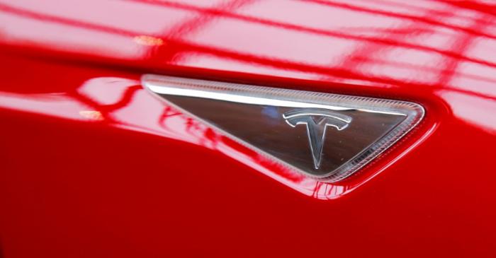 A Tesla logo on a Model S is photographed inside of a Tesla dealership in New York
