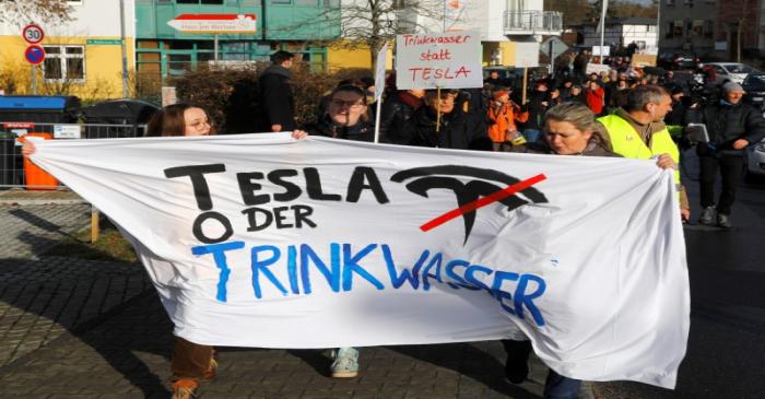 Demonstrators hold anti-Tesla posters during a protest against plans by U.S. electric vehicle