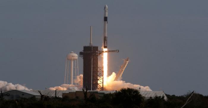 A SpaceX Falcon 9 rocket, carrying the Crew Dragon astronaut capsule, lifts off on an in-flight