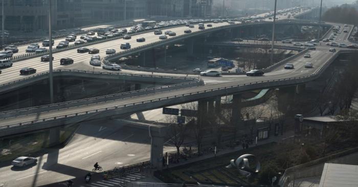 A man cycles under the Guomao Bridge in Beijing