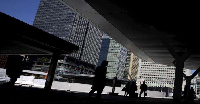People stand outside Tokyo station in a business district in Tokyo