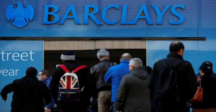 FILE PHOTO: Customers queue outside a branch of Barclays bank in Manchester northern England