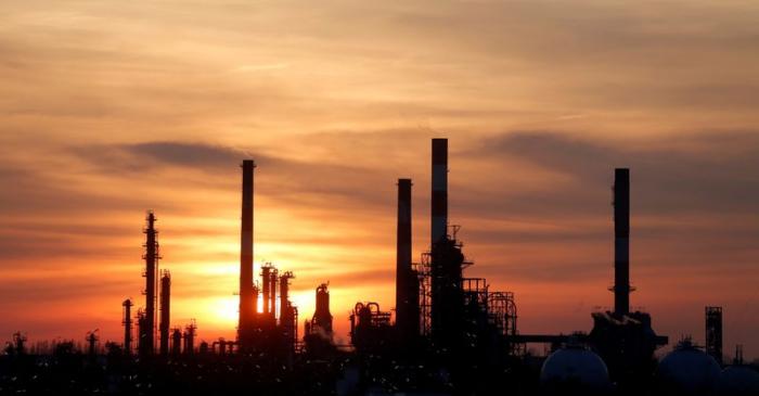 FILE PHOTO: The sun sets behind the chimneys of the Total Grandpuits oil refinery southeast of