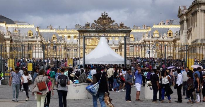 FILE PHOTO: Tourists stand in queue at the entrance to the Chateau de Versailles