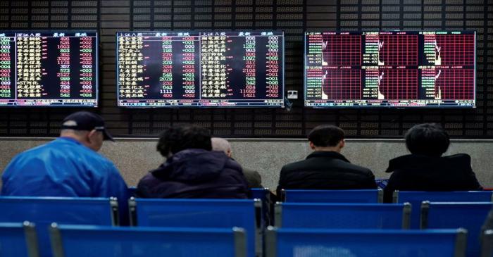 FILE PHOTO:  Investors look at screens showing stock information at a brokerage house in