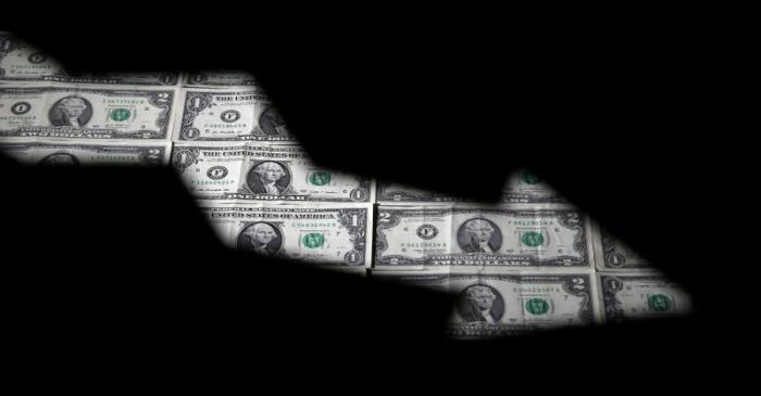 FILE PHOTO: Dollar banknotes are seen through printed stock graph in this illustration