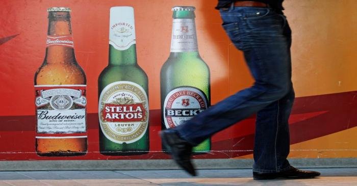 FILE PHOTO:  A man walks near the entrance of Anheuser-Busch InBev headquarters in Leuven