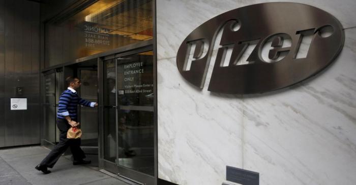 A man enters the employee entrance of the Pfizer World Headquarters building in New York