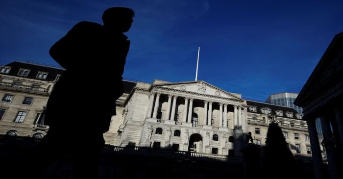 A man is silhouetted as he walks past the Bank of England in the City of London