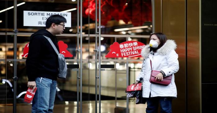 Tourist wears a protective mask as she leaves the Galeries Lafayette department store in Paris