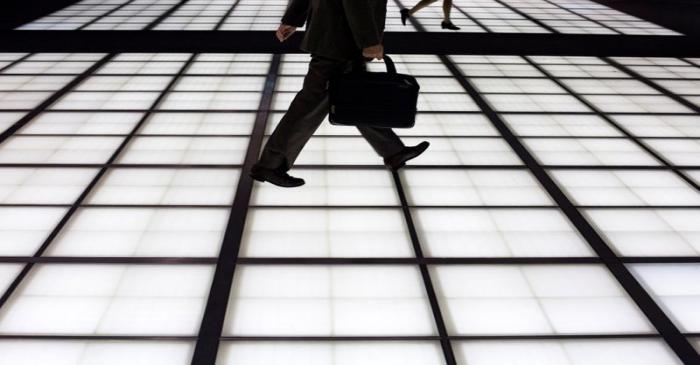 FILE PHOTO:  People cross an illuminated floor at a banking district in central Tokyo
