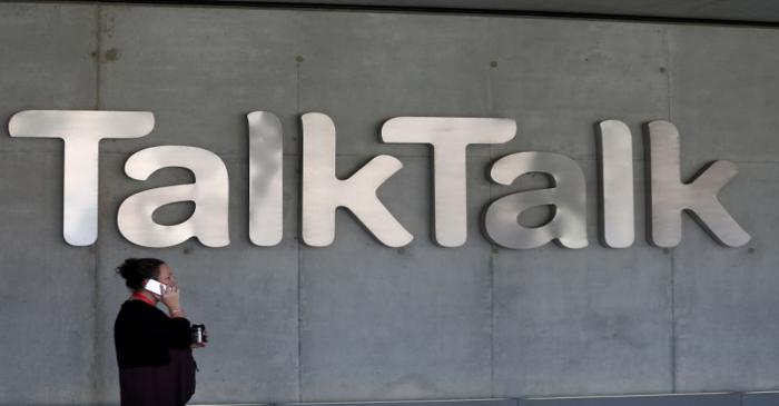 BUSA woman speaks on her phone as she passes a branded logo outside the Talktalk headquarters