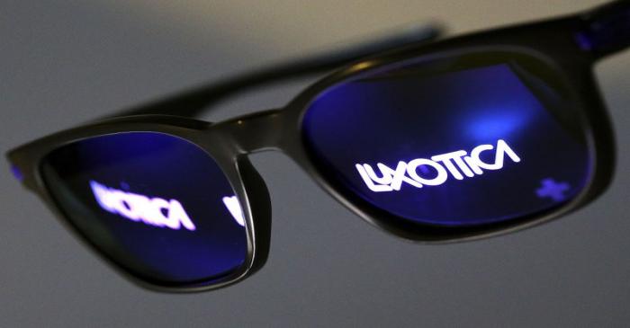 FILE PHOTO: The Luxottica name is reflected in a pair of sunglasses in this photo illustration