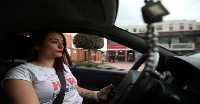 Karen Londono, an Uber driver, drives her car down a central street in Bogota