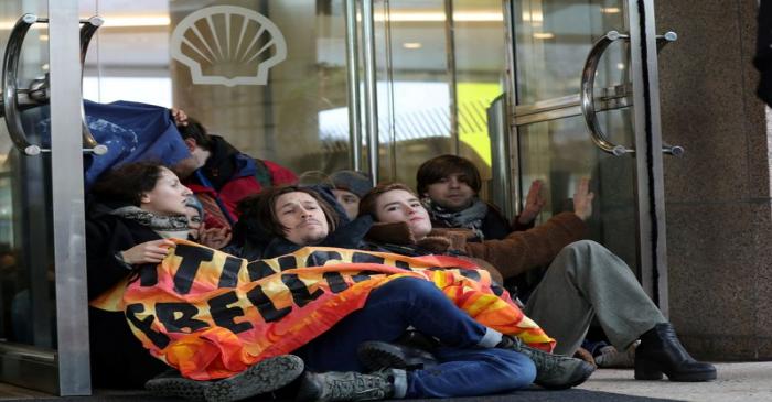 Activists block the entrance of the Shell headquarters in The Hague