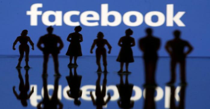 FILE PHOTO: Small toy figures are seen in front of Facebook logo in this illustration picture