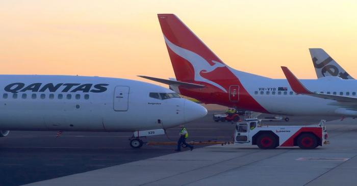 Workers are seen near Qantas Airways, Australia's national carrier, Boeing 737-800 aircraft on