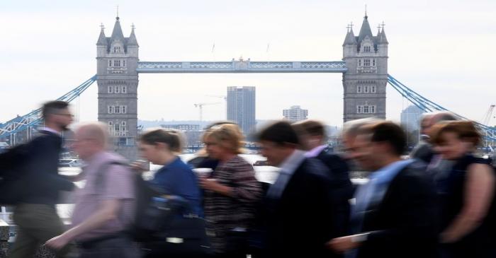 Workers cross London Bridge during the morning rush hour in London