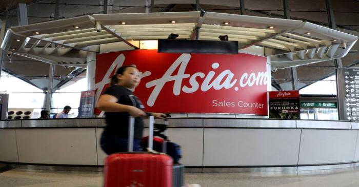 FILE PHOTO:  A woman walks past an AirAsia counter at Kuala Lumpur International Airport in