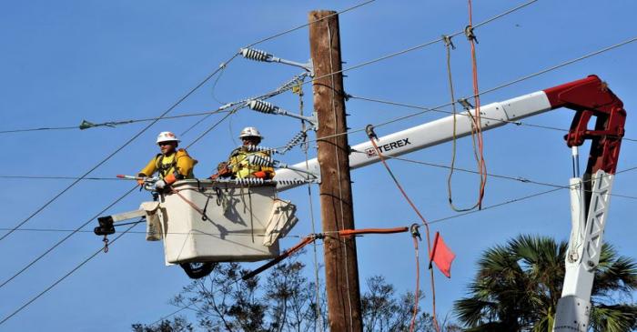 FILE PHOTO: Utility linesmen work on power restoration in the aftermath of Hurricane Michael at