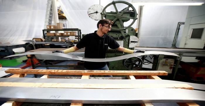 FILE PHOTO:  A worker at perforating company Bion carries a piece of perforated metal at the