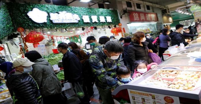 FILE PHOTO:  Customers wear masks as they are buying foods at a food market, in Hong Kong