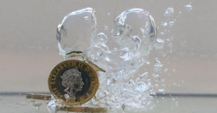 FILE PHOTO:  UK pound coins plunge into water in this illustration picture