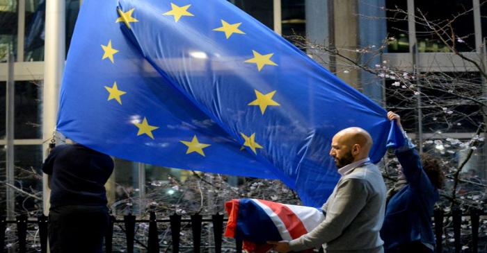 Workers replace the British flag outside the European Parliament building with the European