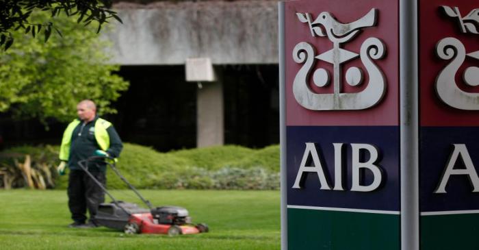 FILE PHOTO:  A gardener mows the grass outside the headquarters of AIB on the day the bank