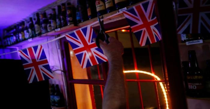 British resident Paul Darwent cuts a cord with British flags inside his bar after the countdown