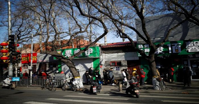 People wearing face masks line up outside a pharmacy as the country is hit by an outbreak of