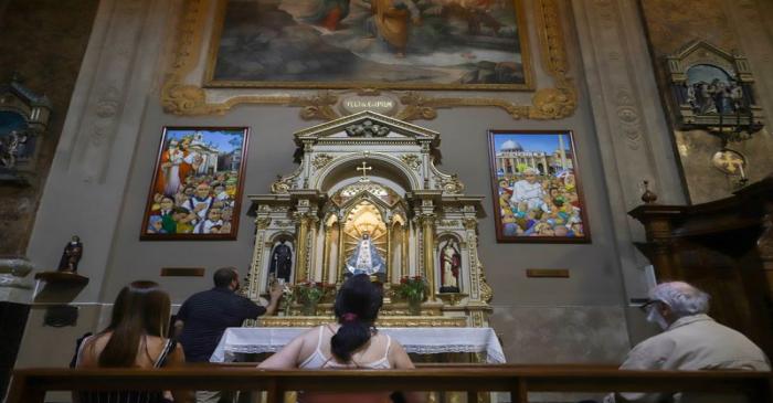 People sit in pews at Pope Francis' old church the Basilica San Jose de Flores, in the district