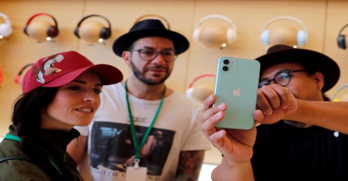 FILE PHOTO: People look at an app on the new iPhone inside the new Apple Store in Mexico City