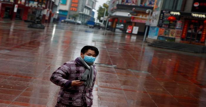 FILE PHOTO: A man wearing a face mask walks in a deserted shopping area in Jiujiang