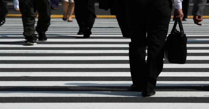 Pedestrians cross a road at Tokyo's business district