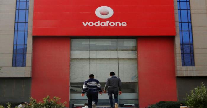 FILE PHOTO: People walk past Vodafone Egypt Telecommunications Co in the Cairo suburb of Maadi