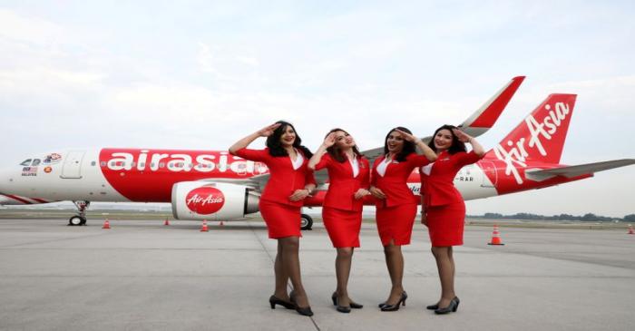 FILE PHOTO: AirAsia crew members pose for a photograph in front of an Airbus A320 plane at