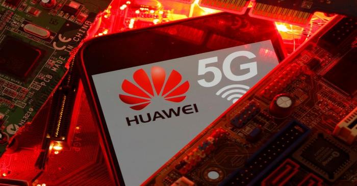 A smartphone with the Huawei and 5G network logo is seen on a PC motherboard in this